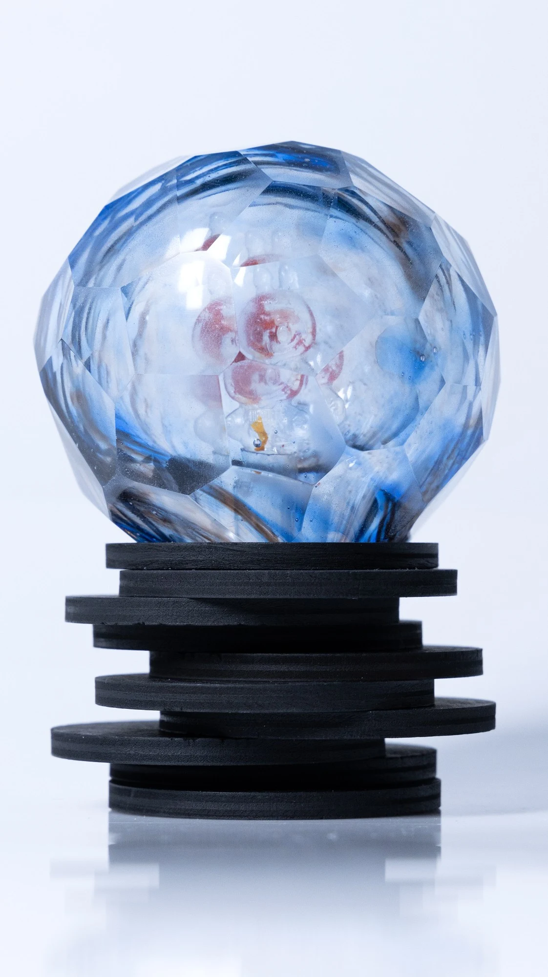 The same piece from another side, the red cast figure seen through the facets