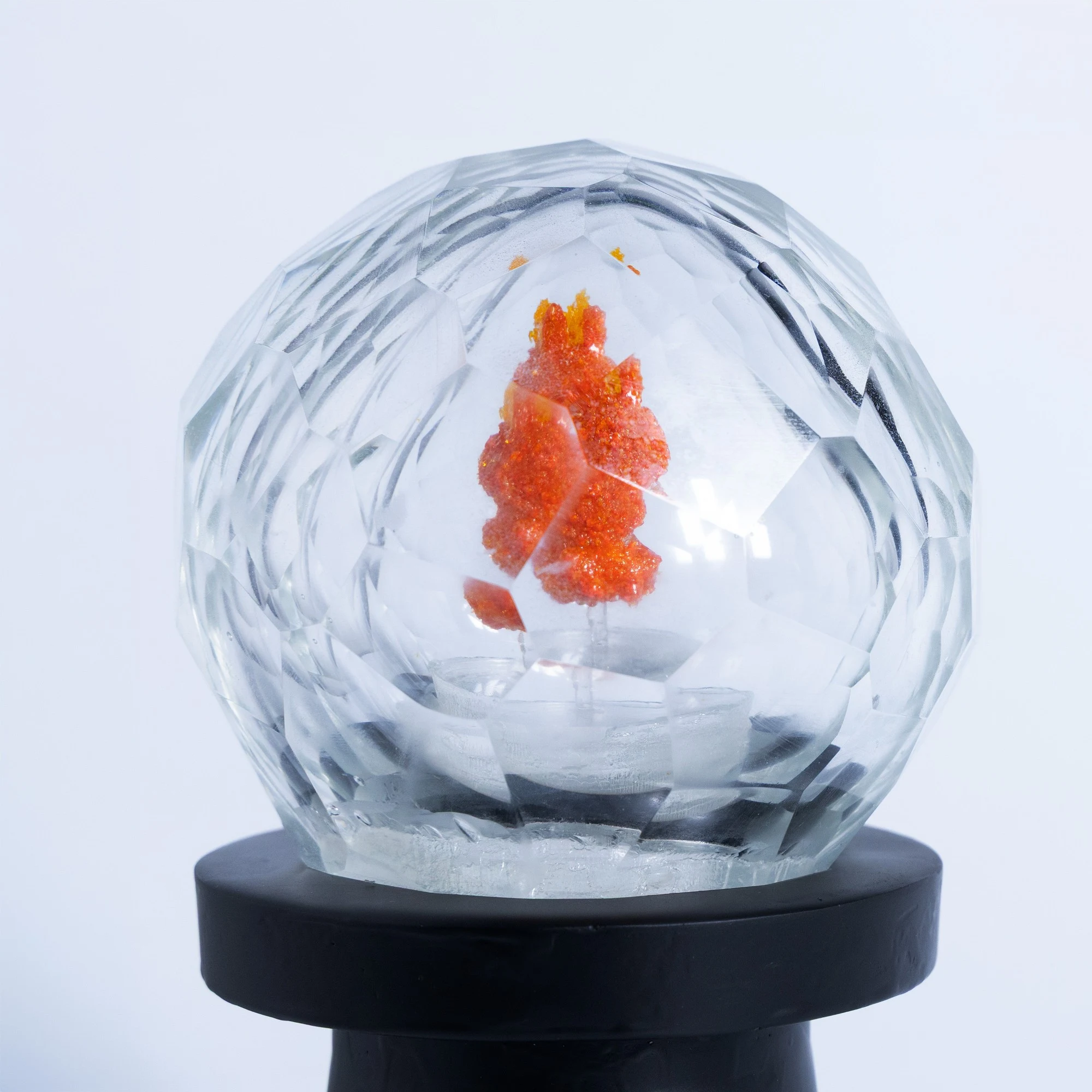 Close view: the orange figure split and shifted by the facets of the sphere