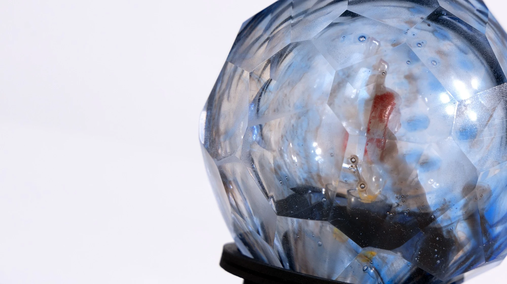 Close view of the sphere: facets, air bubbles and the red cast form inside